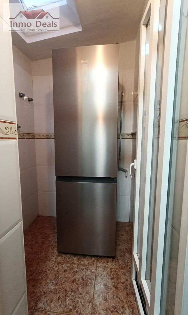 Haier kyl/frys i litet kaklat rum.
