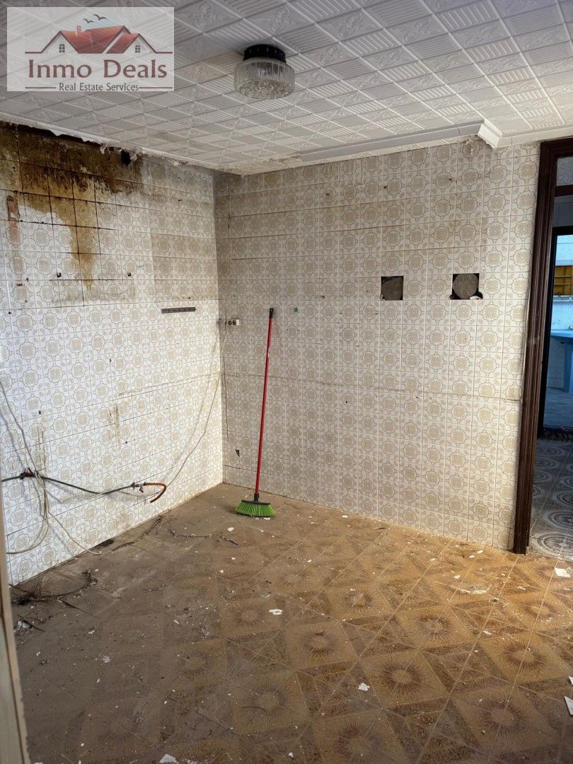 Smutsigt, förfallet kök med kakel och fuktskada, redo för renovering.