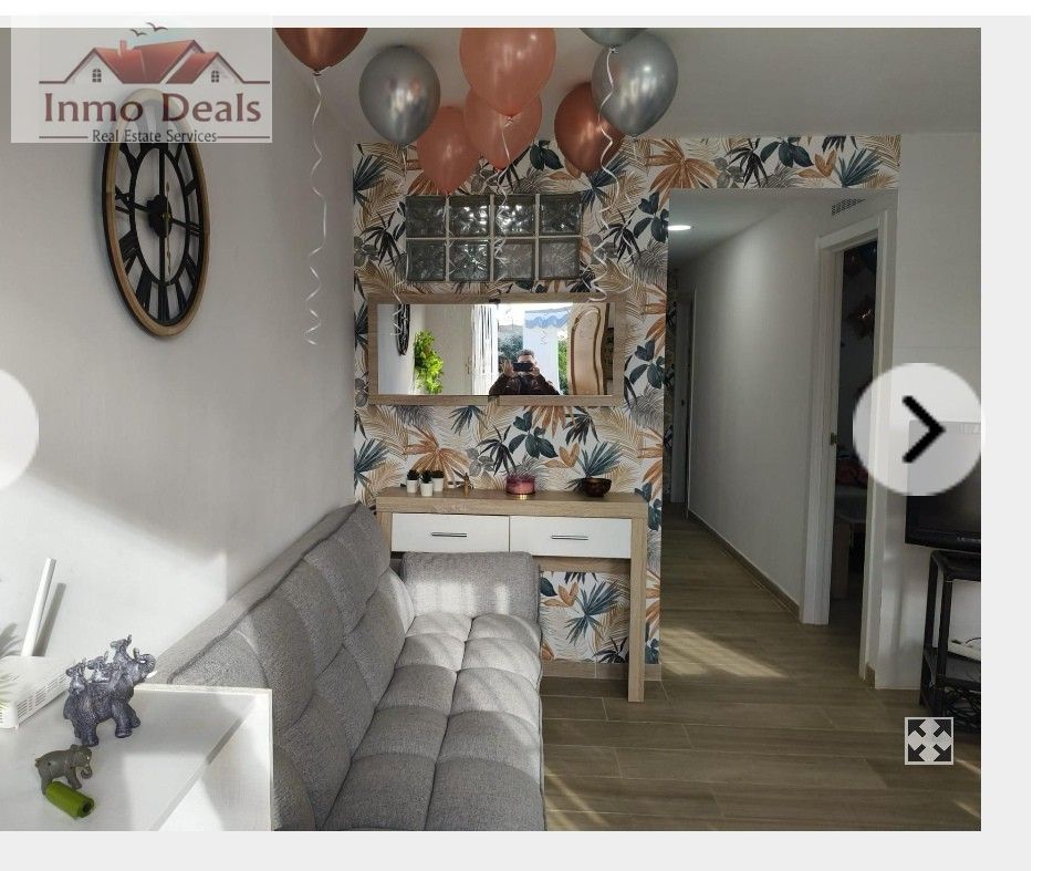 Modernt inrett rum med soffa, tapet och ballonger.