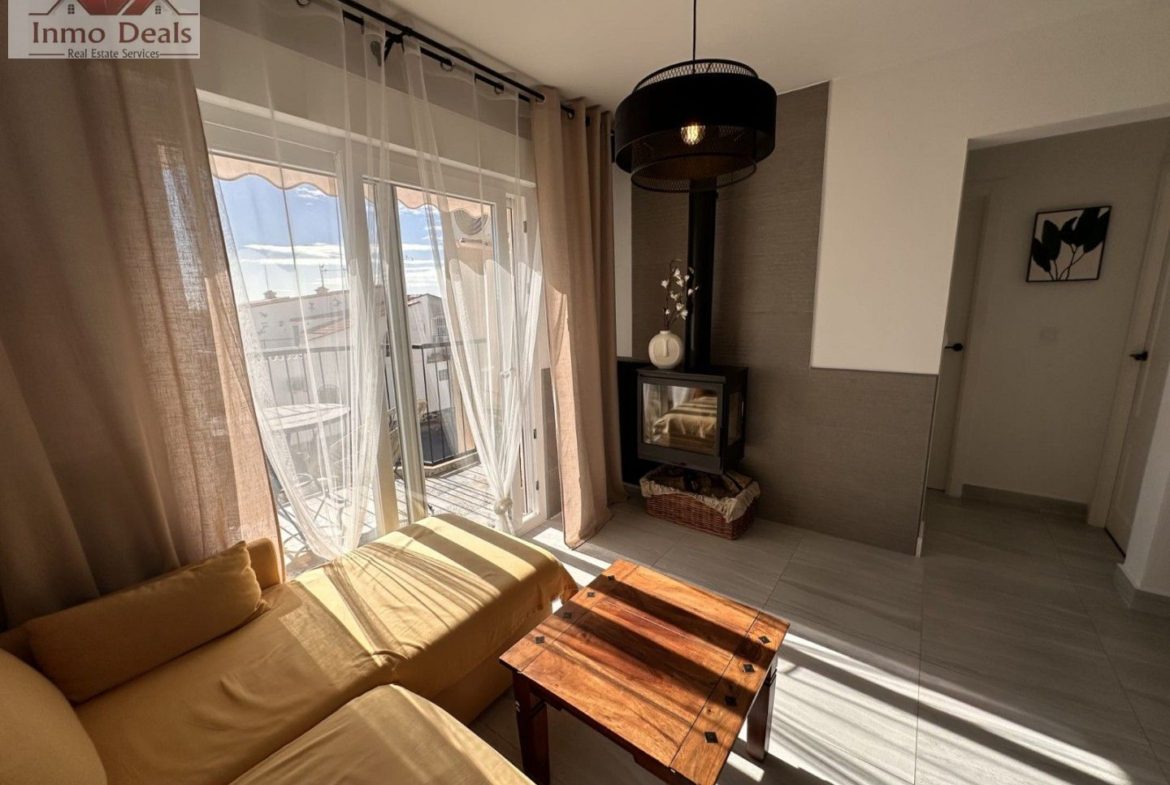 Ljust vardagsrum med gul soffa, modern kamin och balkong.